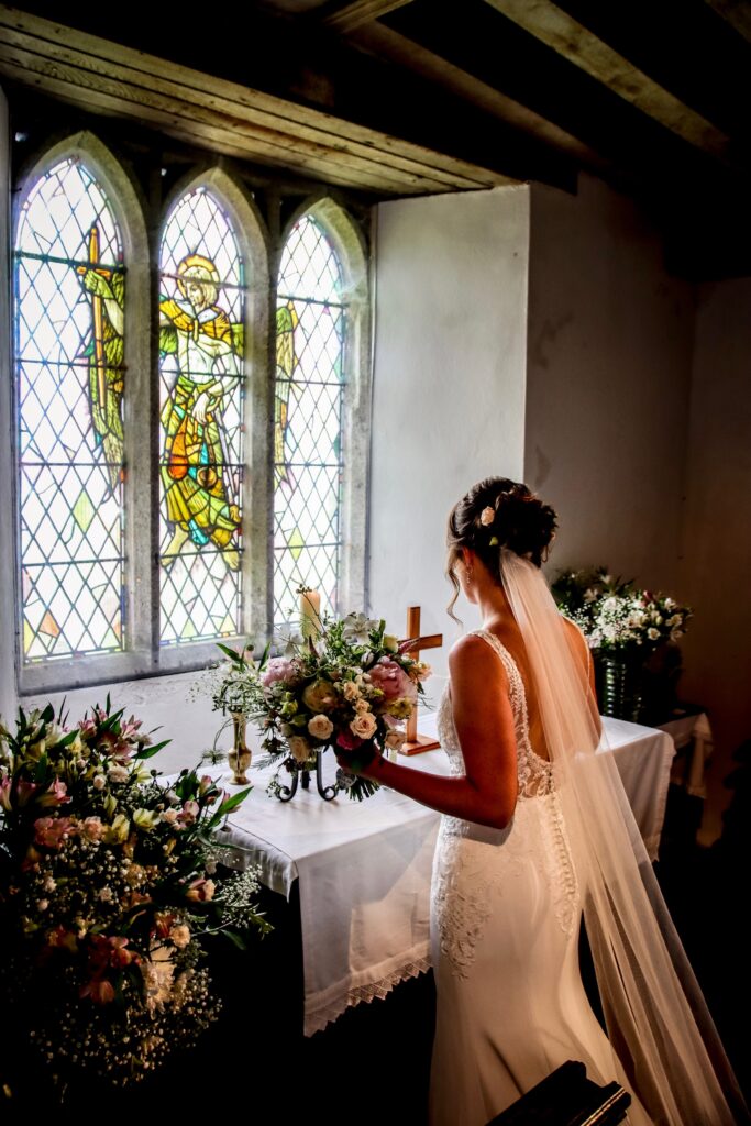 Bride contemplating the floral arrangements - L Spinks Photography